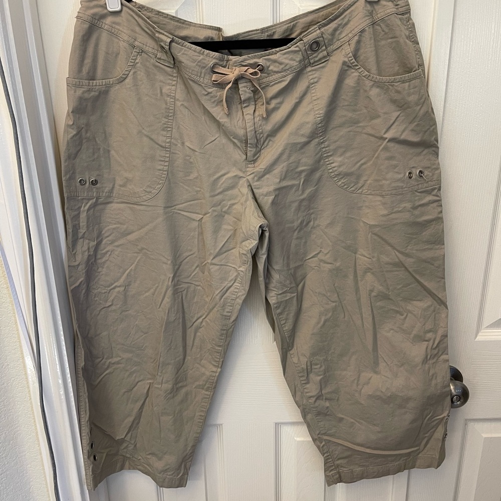 Khaki capri pants with grommet detail.